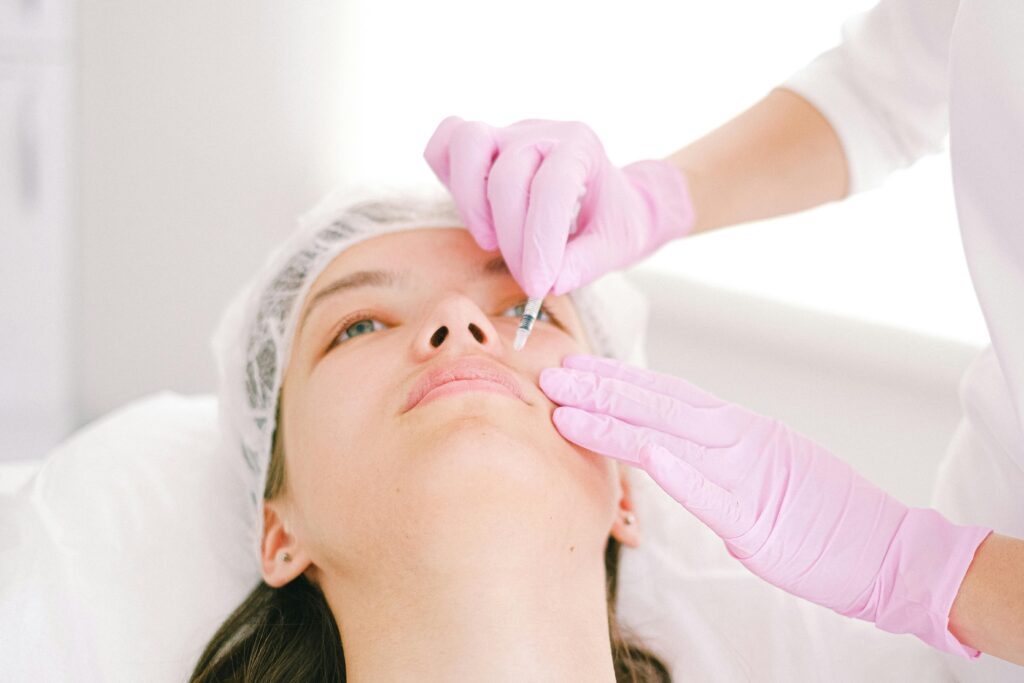 Woman receiving a facial cosmetic injection in a professional clinic setting.